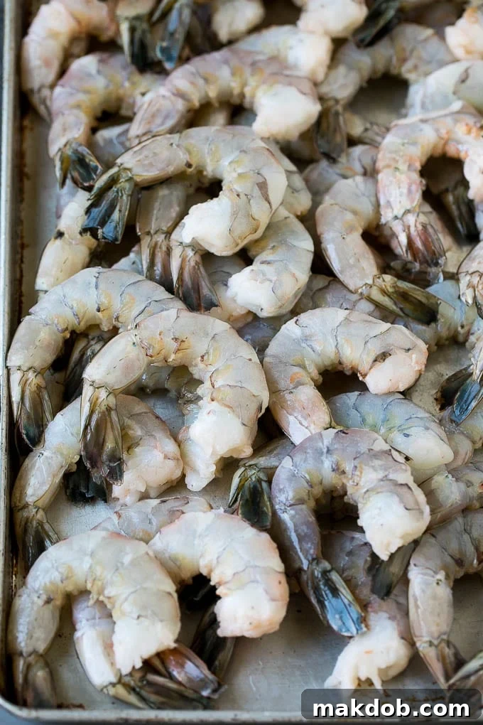 Raw shrimp on a sheet pan.