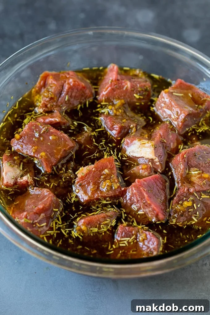 Tender Beef Cubes Marinating for Shish Kabobs Steak cubes in a bowl of marinade.
