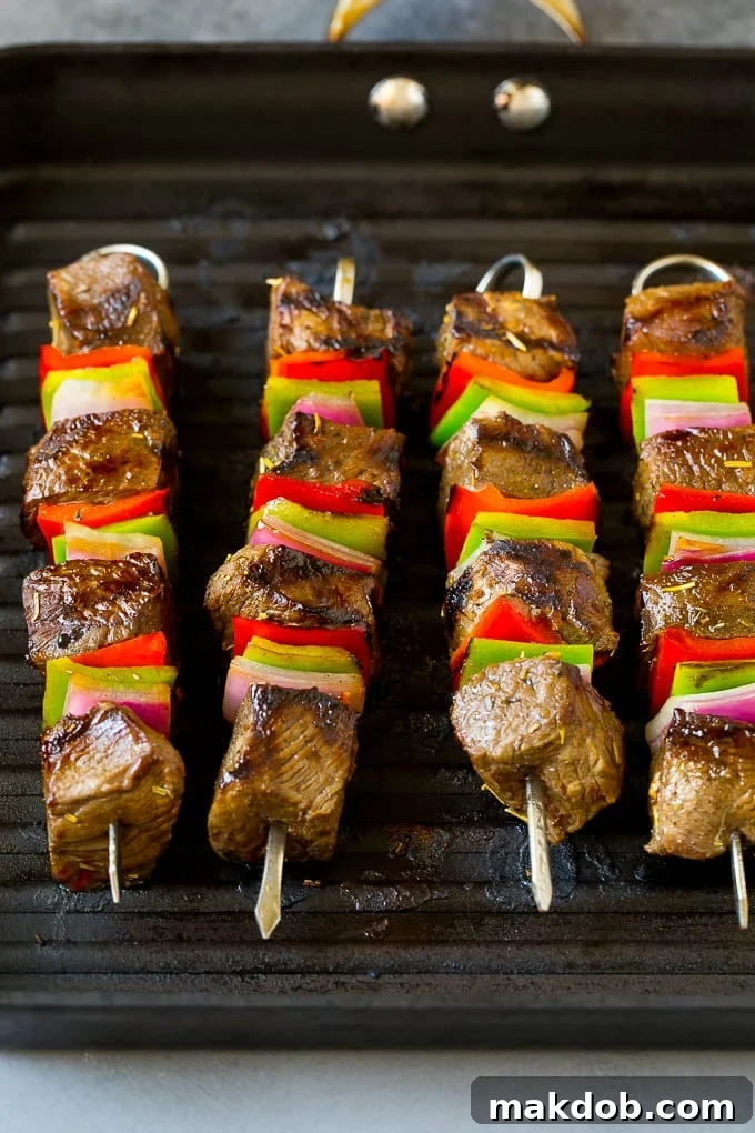 Sizzling Beef Shish Kabobs on an Indoor Grill Pan Beef skewers cooking on a grill pan.