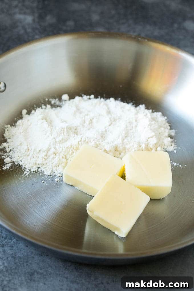 Butter melting and flour being whisked into it in a skillet to create a roux, the base for turkey gravy.
