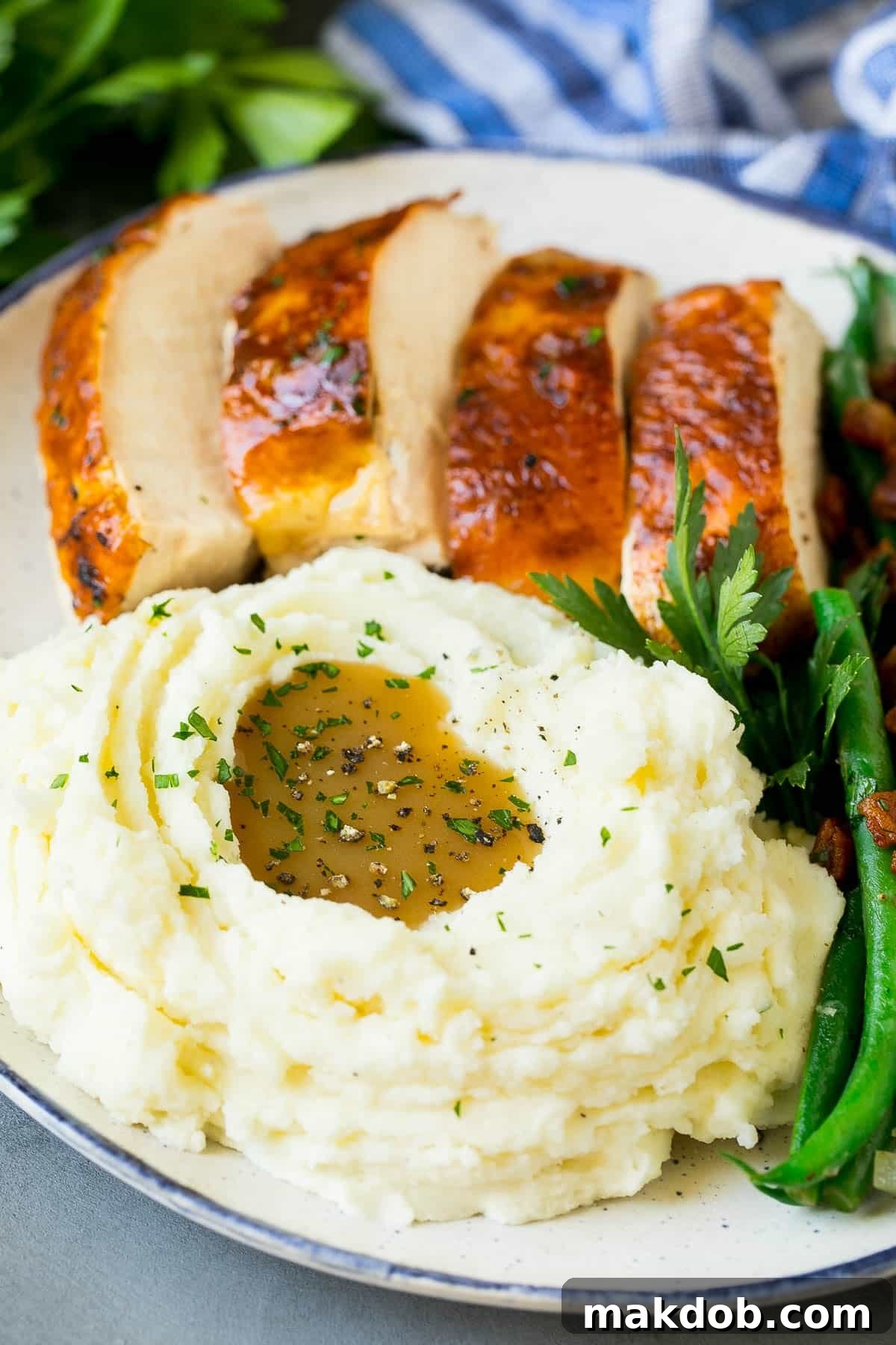 Crock pot mashed potatoes on a plate with turkey, green beans and gravy.