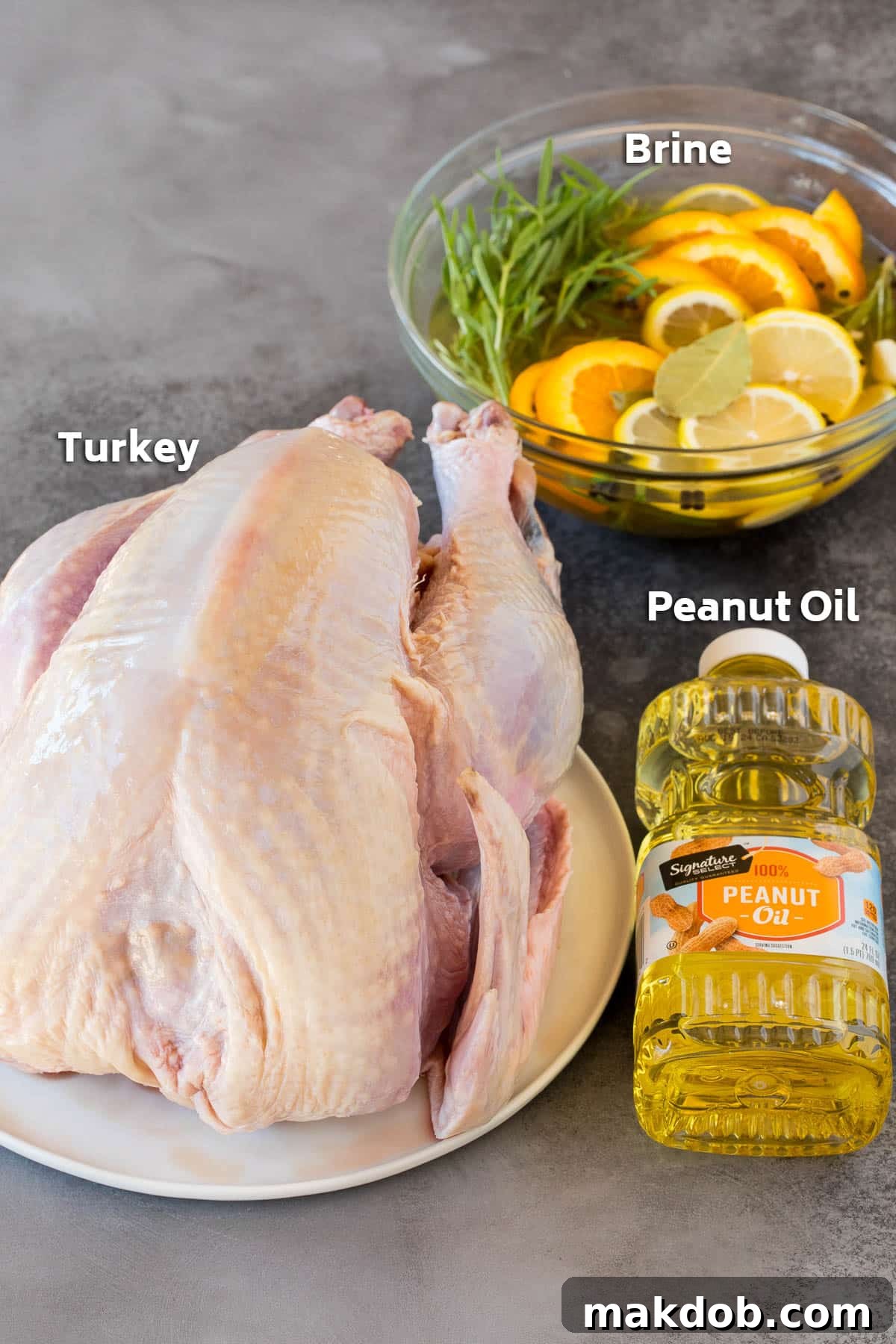 Ingredients for deep-fried turkey including a raw turkey, a bottle of peanut oil, and a bowl of turkey brine.