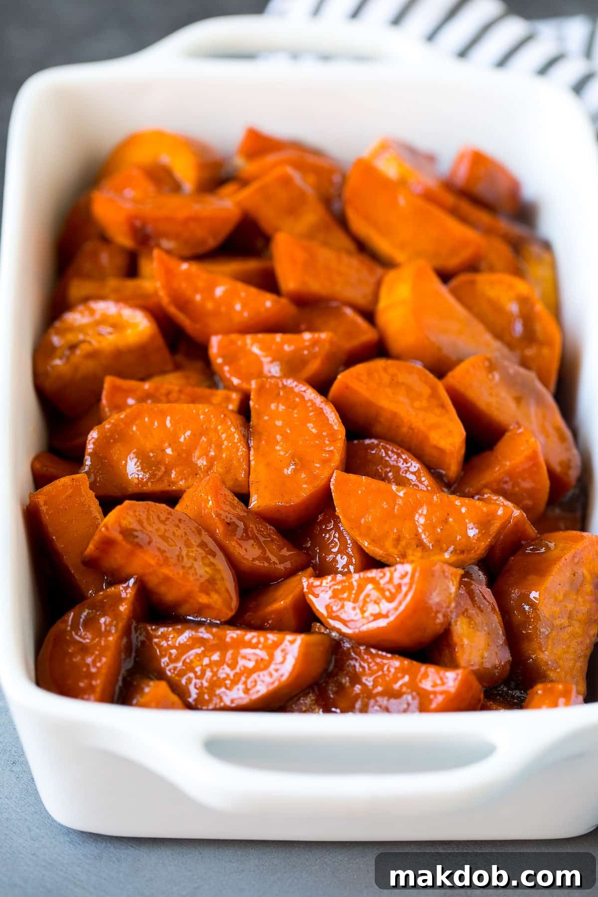 Sweet Potato Candies 6 A large baking dish filled with golden-brown candied sweet potatoes, perfectly caramelized and glistening.