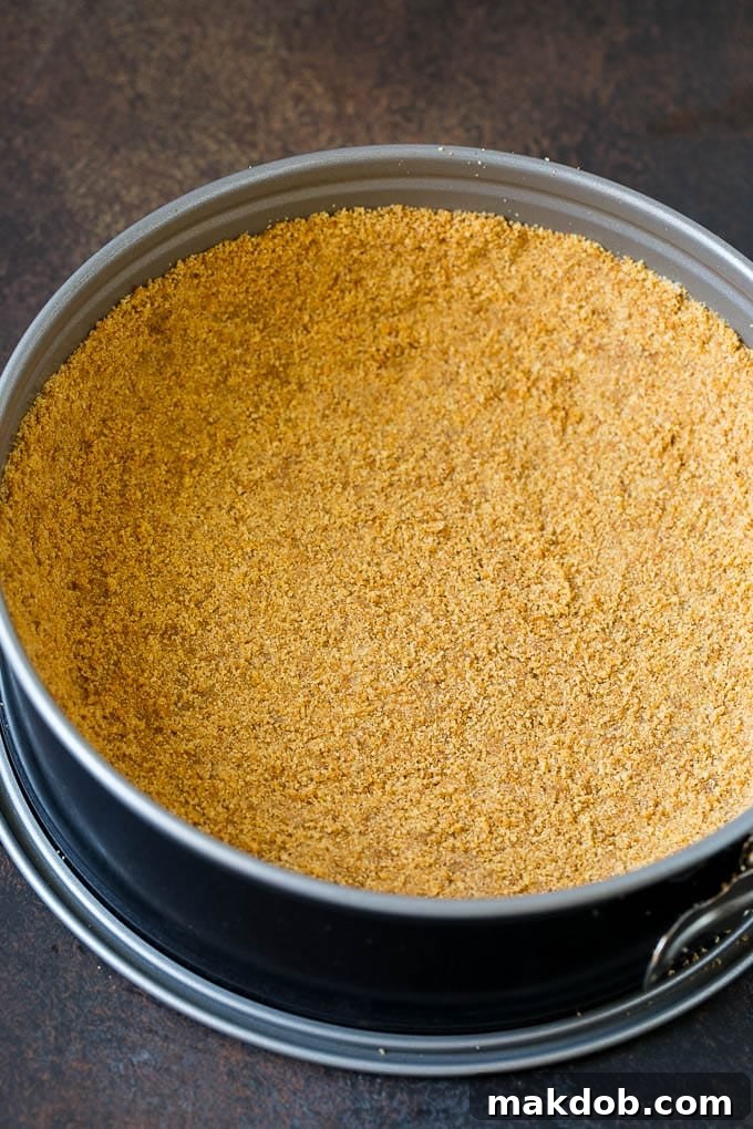 Pumpkin Pie Cheesecake Recipe | Pumpkin Cheesecake #cake #cheesecake #pumpkin #fall #thanksgiving #dessert #dinneratthezoo A golden brown graham cracker crust firmly pressed into the bottom and sides of a springform pan, ready for the creamy pumpkin filling.