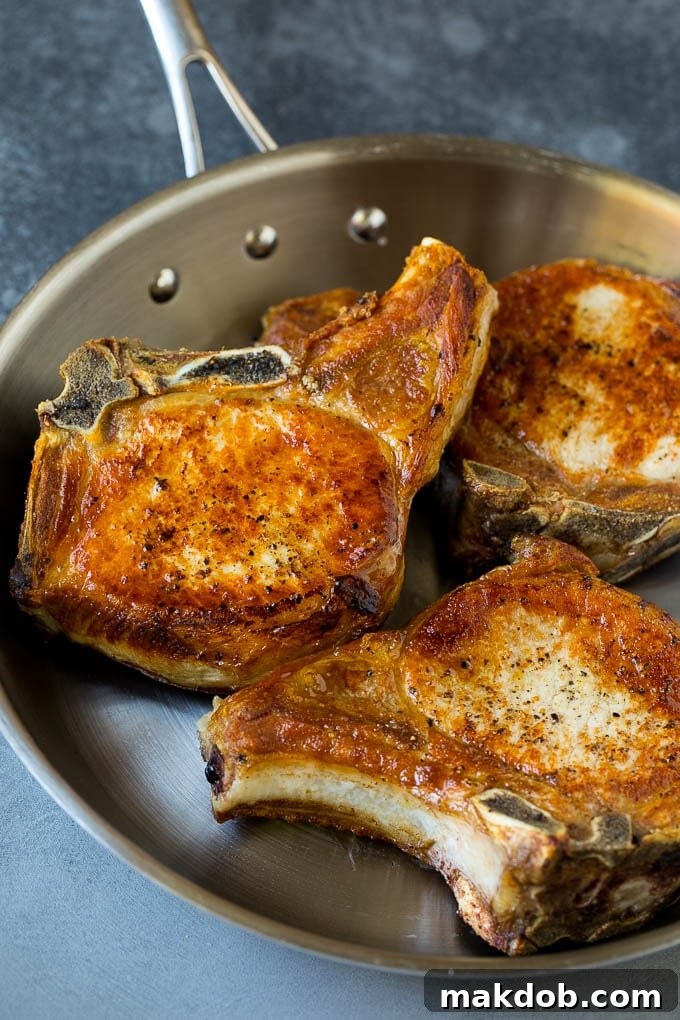Browned pork chops in a skillet, ready for the gravy.