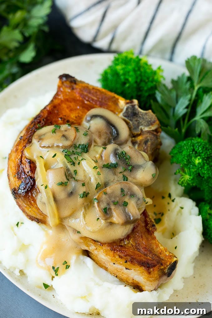 Smothered pork chops served with fluffy mashed potatoes and vibrant green broccoli.