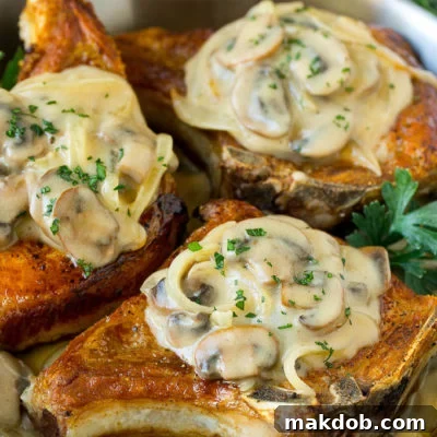 A pan of smothered pork chops topped with mushroom and onion gravy.