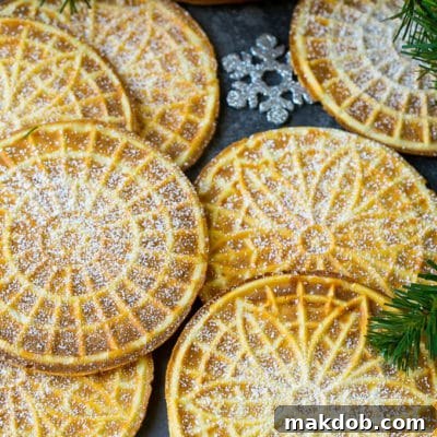 Pizzelle cookies cooked to golden brown and coated in powdered sugar.