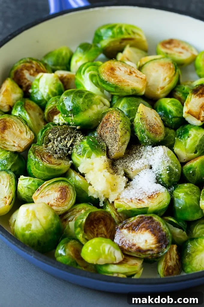 Sauteed Brussels Sprouts Recipe | Brussels Sprouts Side Dish #brusselssprouts #sprouts #veggies #sidedish #garlic #vegetarian #dinner #dinneratthezoo Brussels sprouts in a pan, seasoned with salt, pepper, garlic, and a blend of dried herbs.