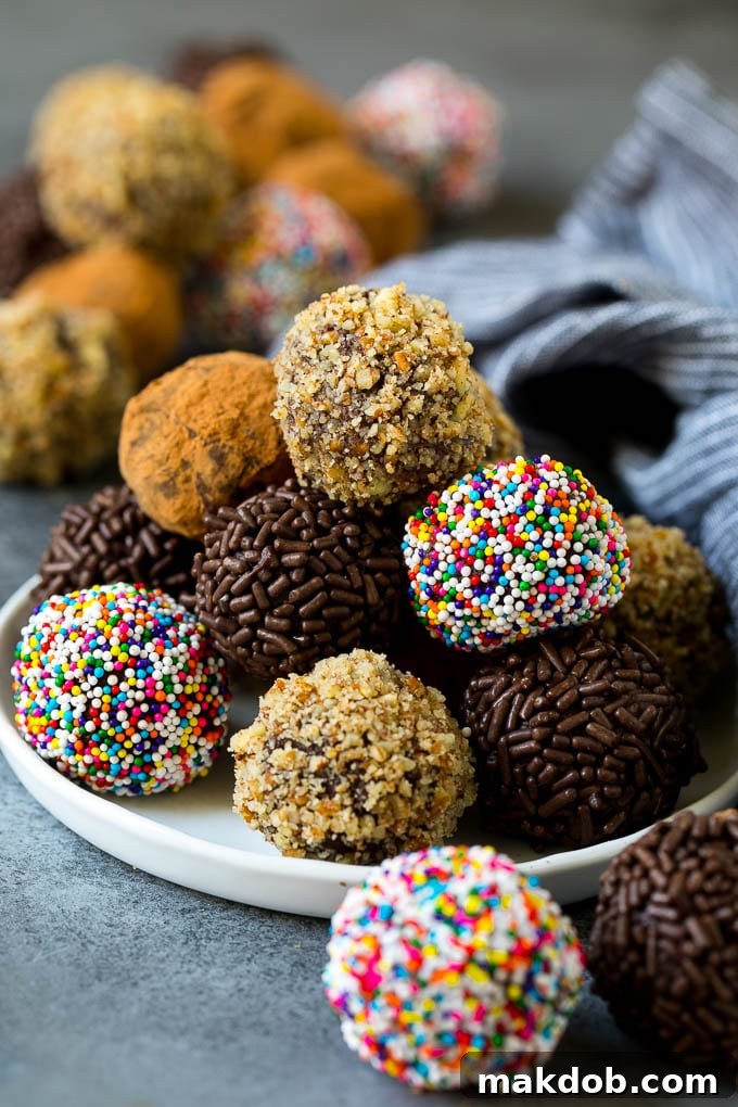 Rich chocolate truffles coated in nuts, sprinkles, and cocoa powder, arranged on a plate.