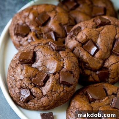 Brownie cookies on a serving plate, topped with chocolate chunks.