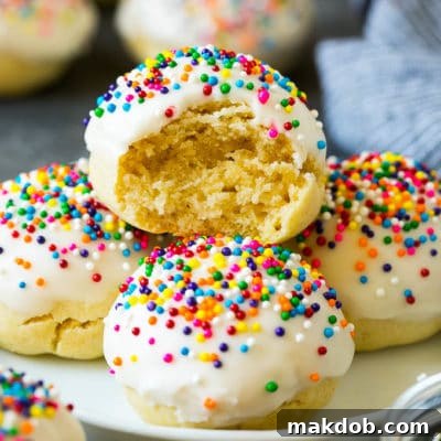 A plate of Italian cookies with a bite taken out of one.