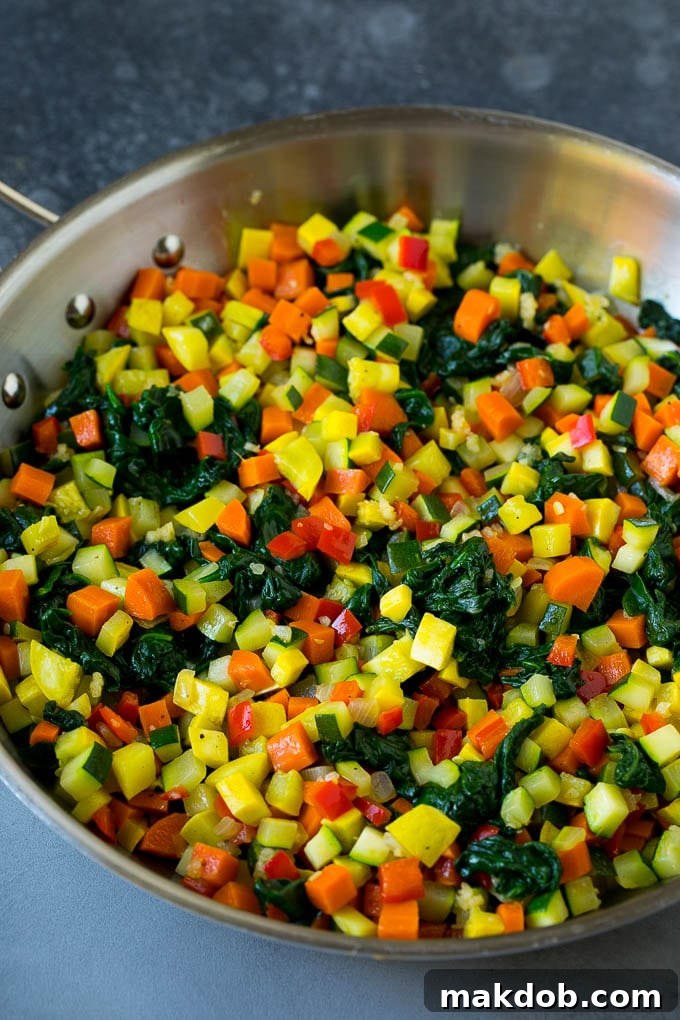 Vegetable Lasagna Recipe | Vegetarian Lasagna #lasagna #vegetarian #veggies #cheese #pasta #dinner #dinneratthezoo A skillet filled with vibrant sauteed vegetables including zucchini, squash, spinach, carrots, and bell peppers.