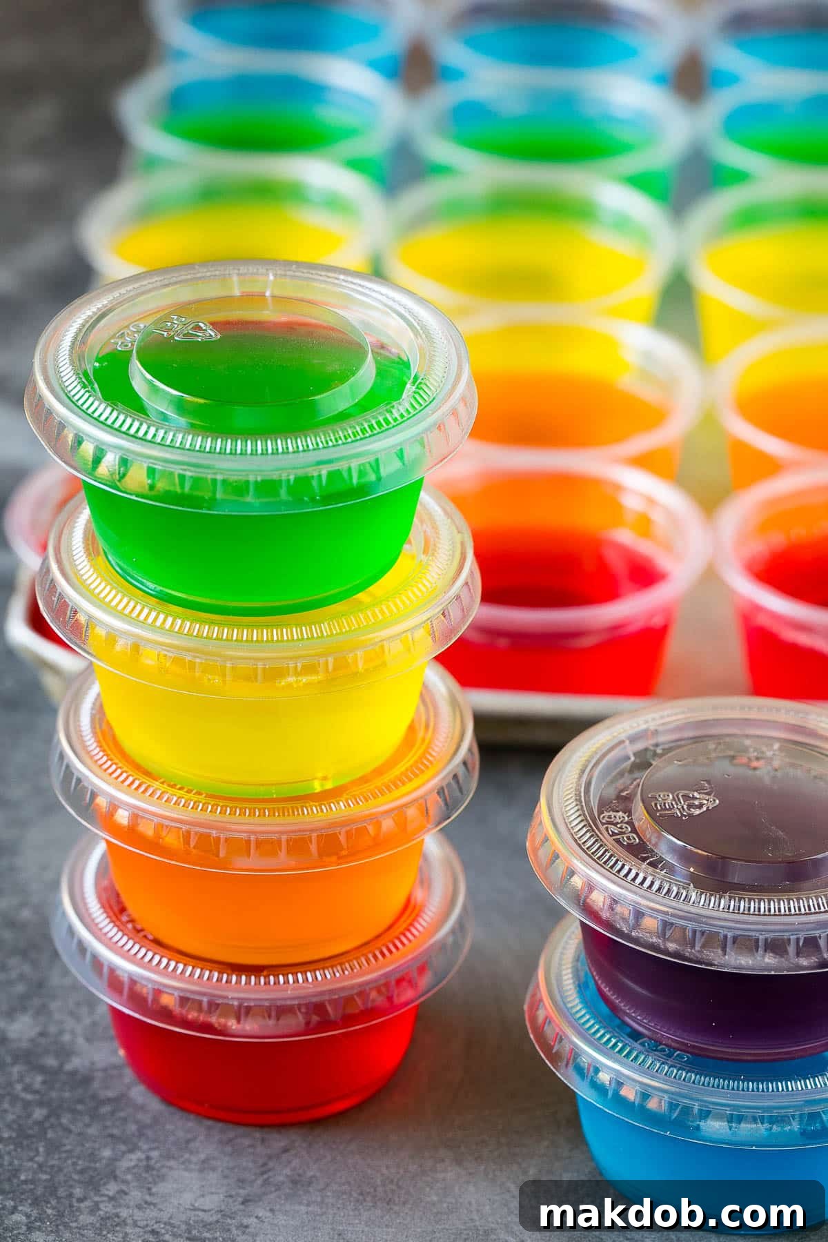 Ultimate Jello Shot Guide 5 A stack of Jello shots in plastic containers, ready for a party.