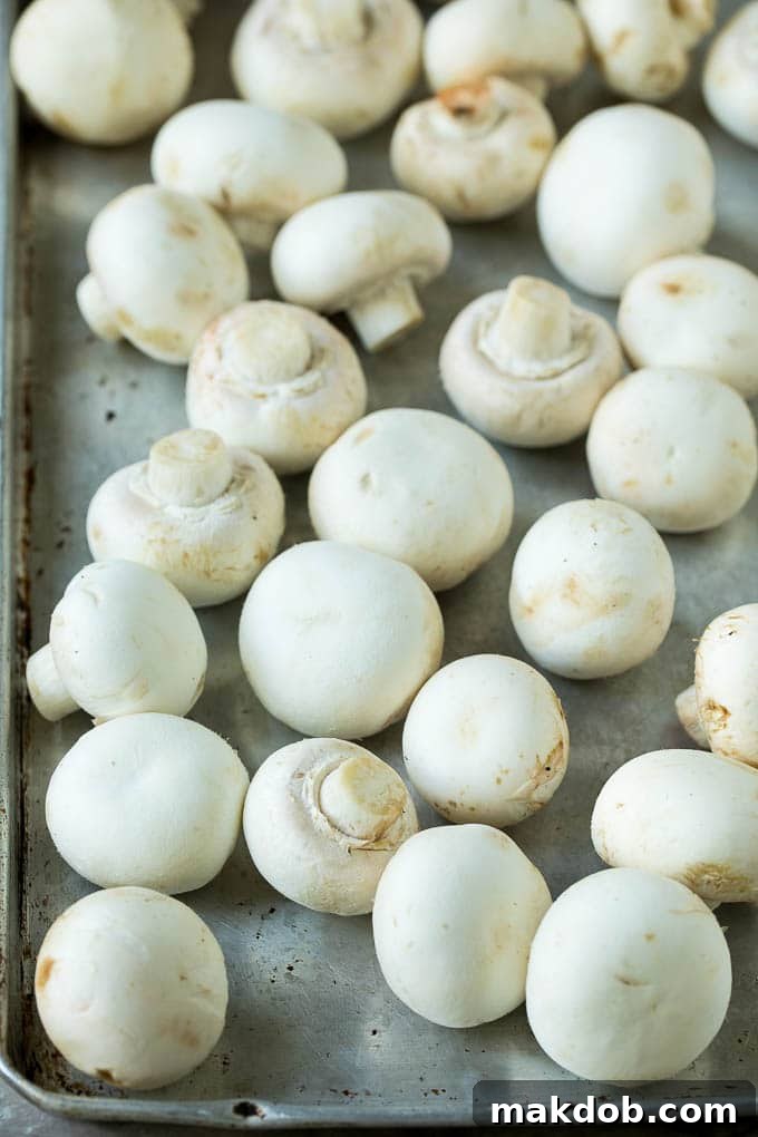 Fried Mushrooms Recipe #mushrooms #appetizer #snack #dinneratthezoo Fresh white button mushrooms neatly arranged on a sheet pan, ready for cleaning and preparation.