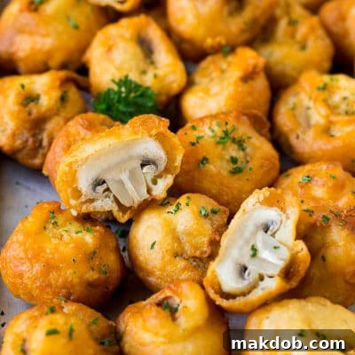 Crispy Golden Fried Mushrooms 2 A sheet pan of fried mushrooms garnished with parsley.