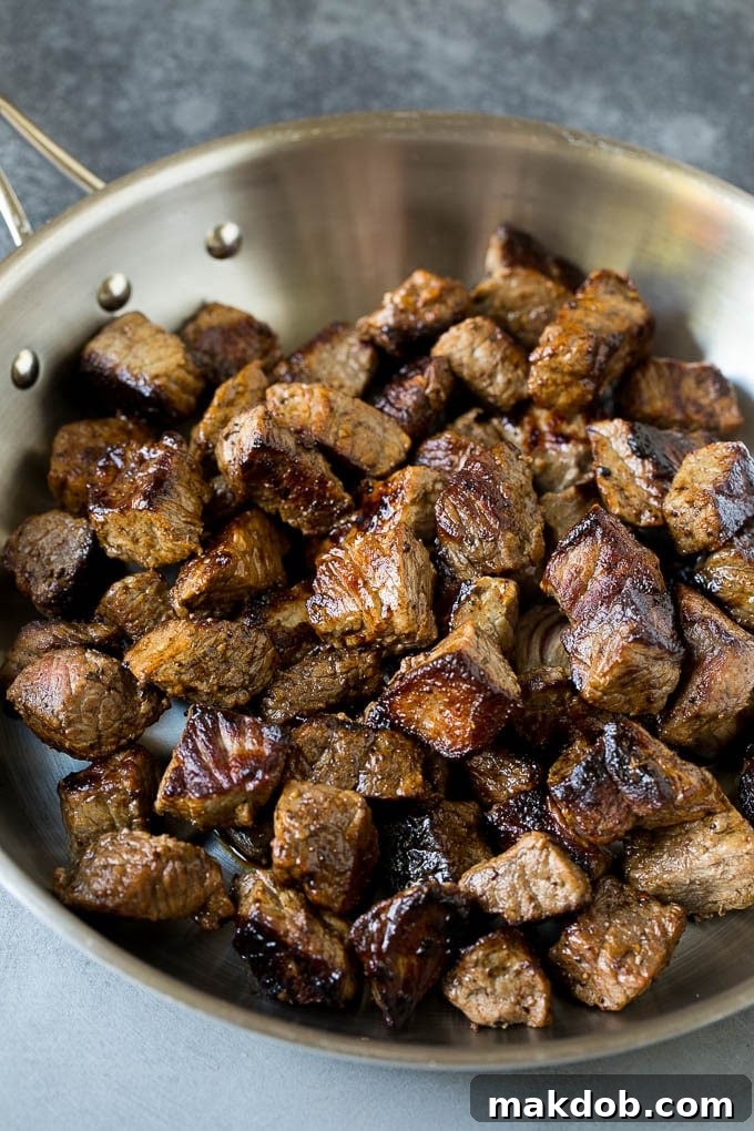 Seared pieces of sirloin steak in a frying pan.
