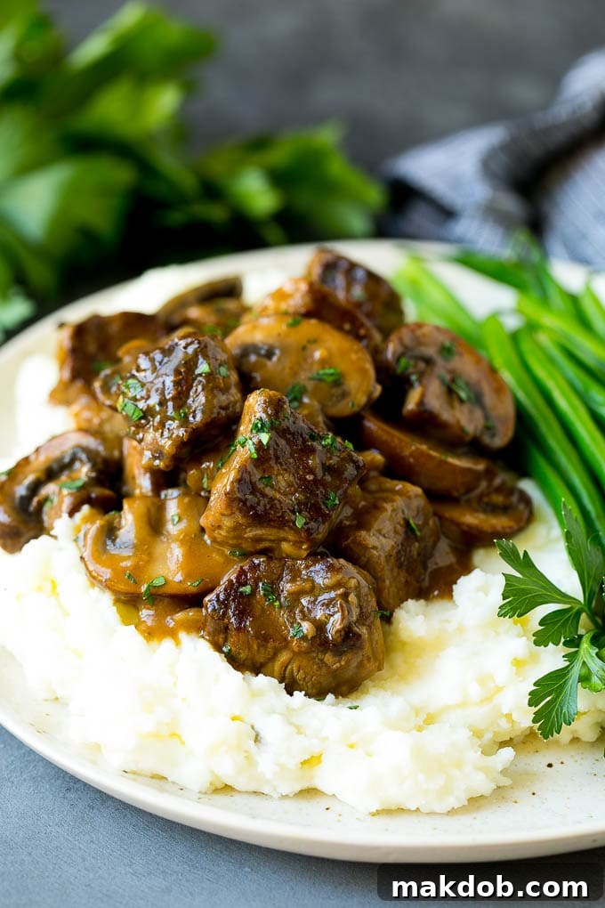 Beef tips served over mashed potatoes with green beans.