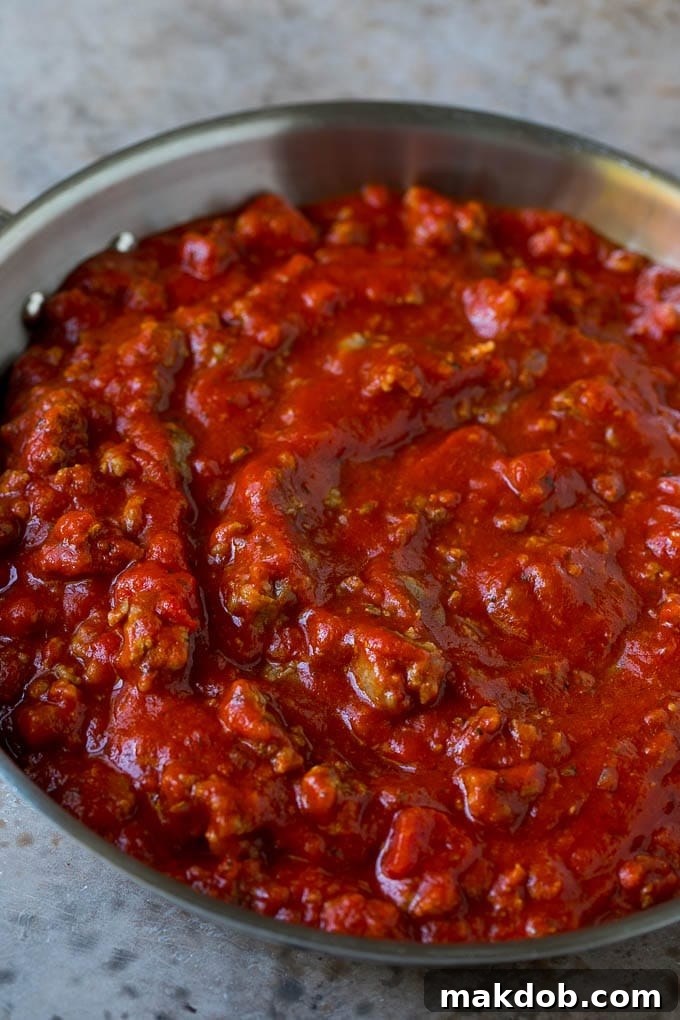 Simmering Meat Sauce for Baked Spaghetti Rich meat sauce simmering in a large skillet, ready for the spaghetti.
