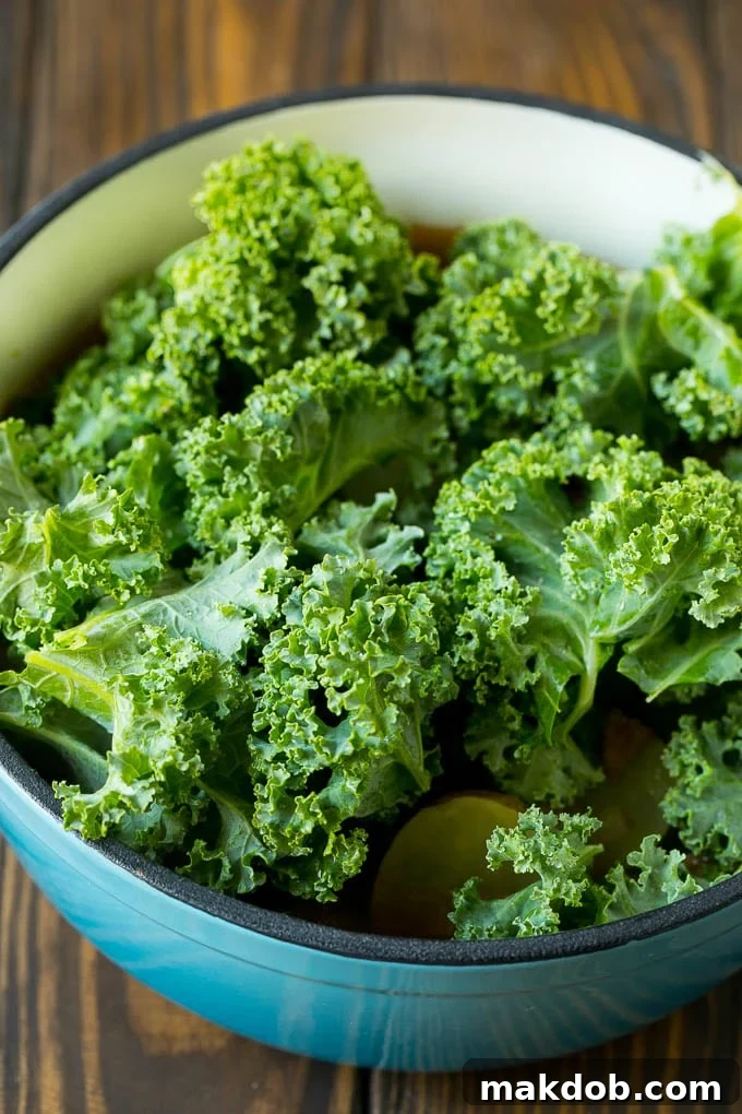 Fresh kale leaves going into a pot of soup.