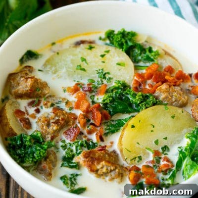 A beautiful bowl of homemade Zuppa Toscana, garnished with crispy bacon and fresh parsley.