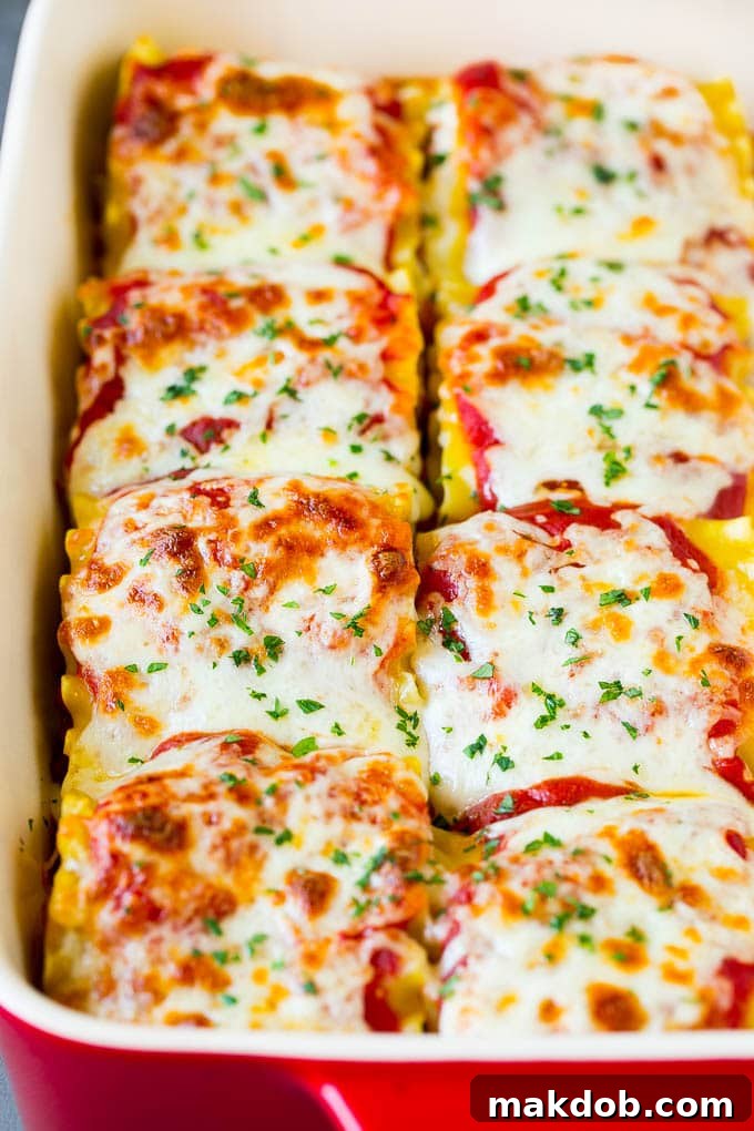 Baked lasagna roll ups topped with perfectly melted mozzarella cheese, garnished with fresh parsley.