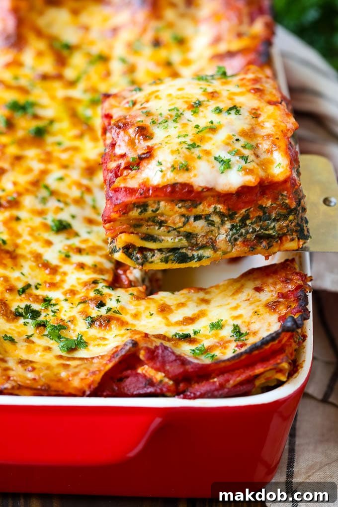 Spinach Lasagna Recipe | Vegetarian Lasagna #lasagna #spinach #cheese #pasta #italianfood #dinner #dinneratthezoo A spatula serving up a slice of spinach lasagna.