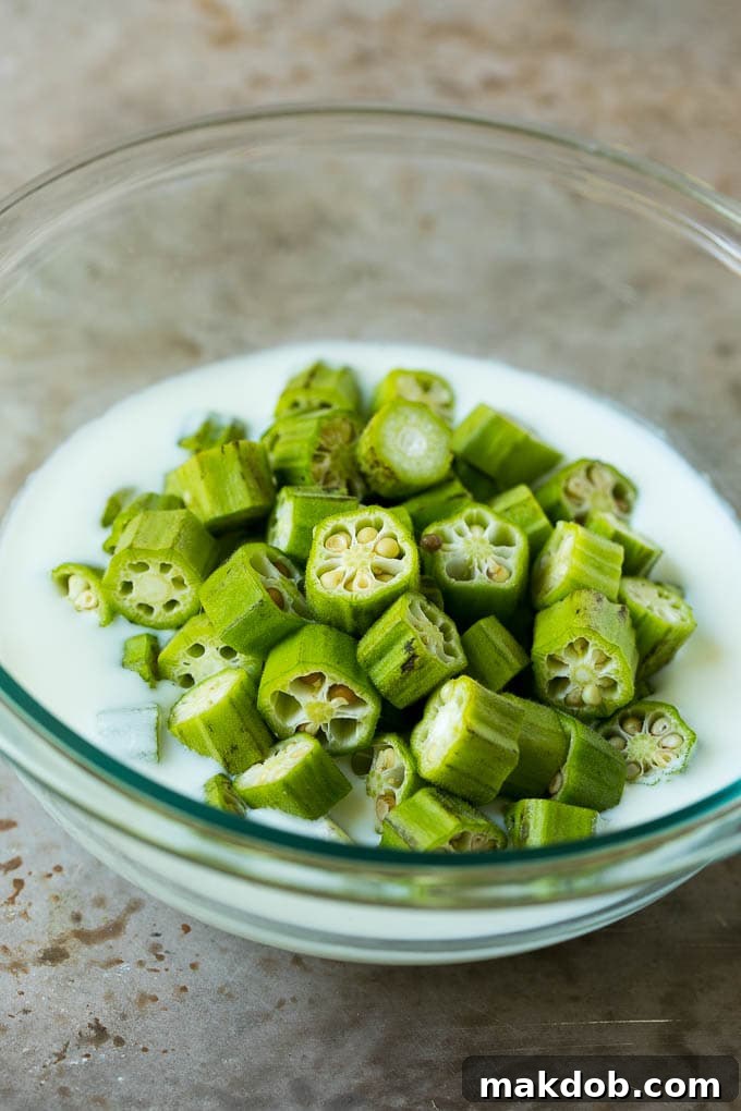Sliced okra in a bowl of buttermilk.