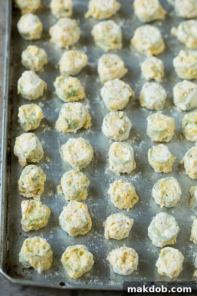 Breaded okra slices on a sheet pan.