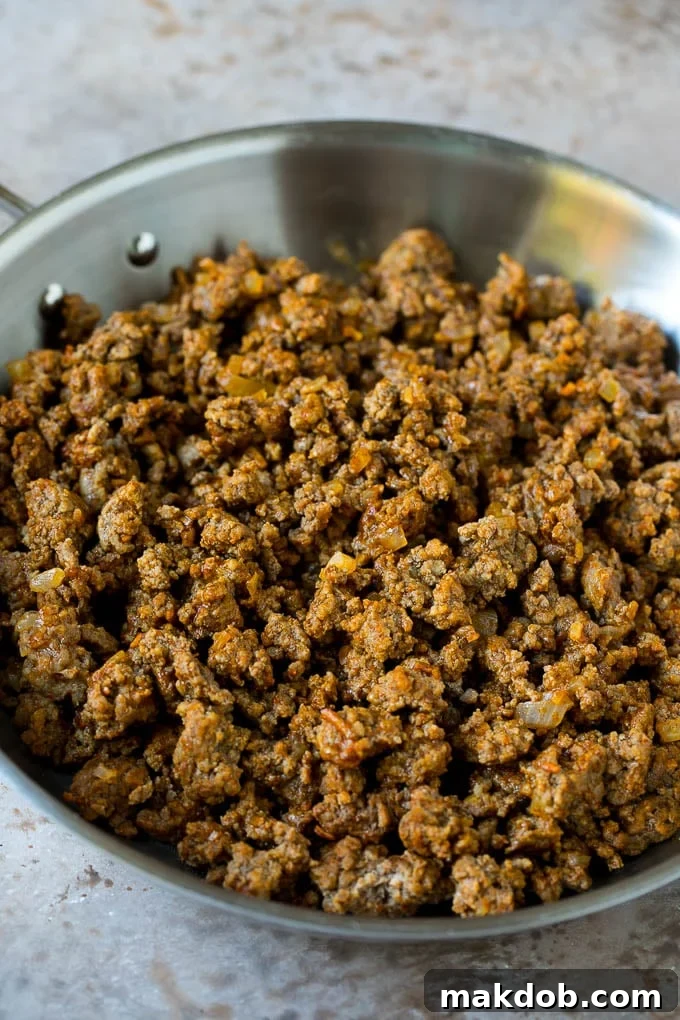 Ultimate Beef Enchiladas 3 Seasoned ground beef with diced onions in a skillet, ready for enchilada filling.