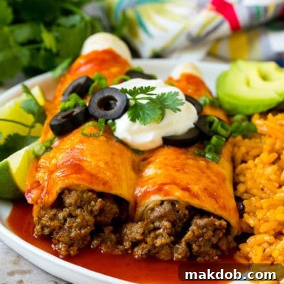Ultimate Beef Enchiladas 7 A plate of beef enchiladas topped with sour cream, olives and green onions.