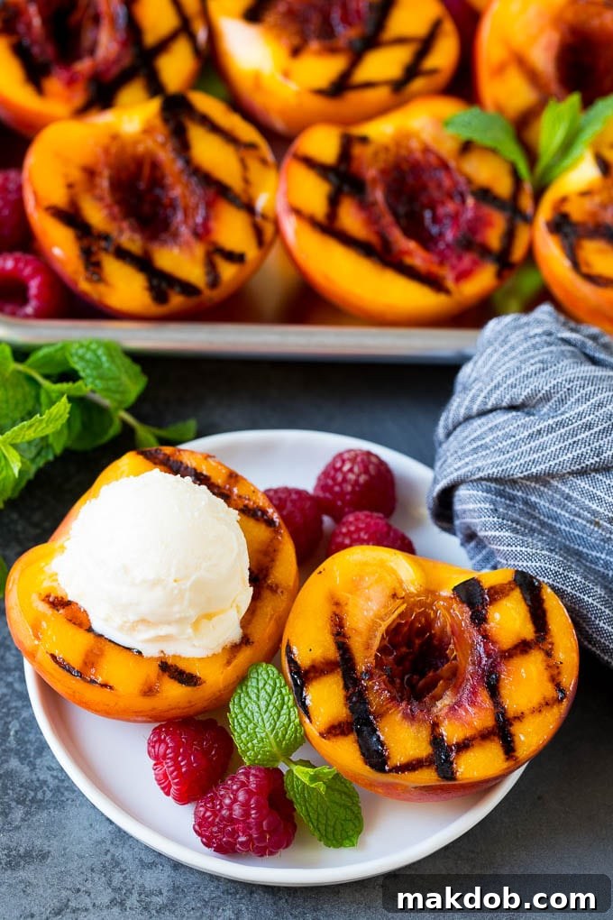 Grilled peaches topped with a scoop of vanilla ice cream.