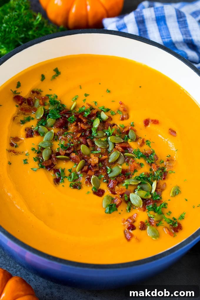 Creamy Pumpkin Soup with Bacon and Herbs A large pot filled with creamy pumpkin soup, garnished with crispy bacon and fresh herbs, ready to be served.
