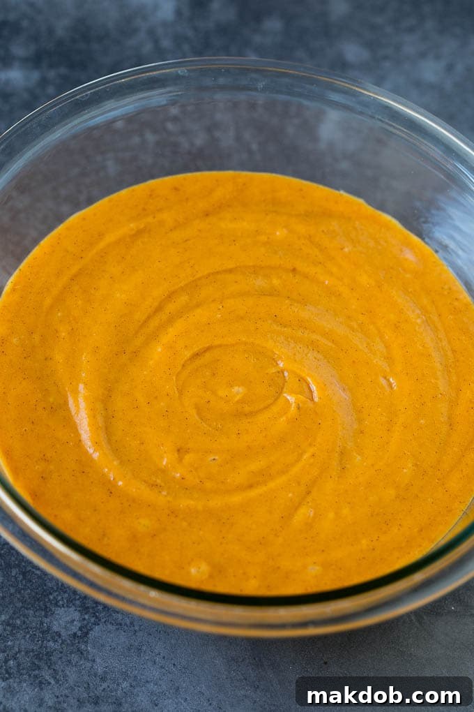 Smooth Pumpkin Muffin Batter A bowl of rich, orange pumpkin muffin batter, ready for baking.
