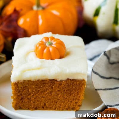A slice of pumpkin cake topped with cream cheese frosting.