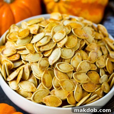 A bowl of perfectly golden-brown roasted pumpkin seeds, ready to be enjoyed as a snack, symbolizing autumn comfort.
