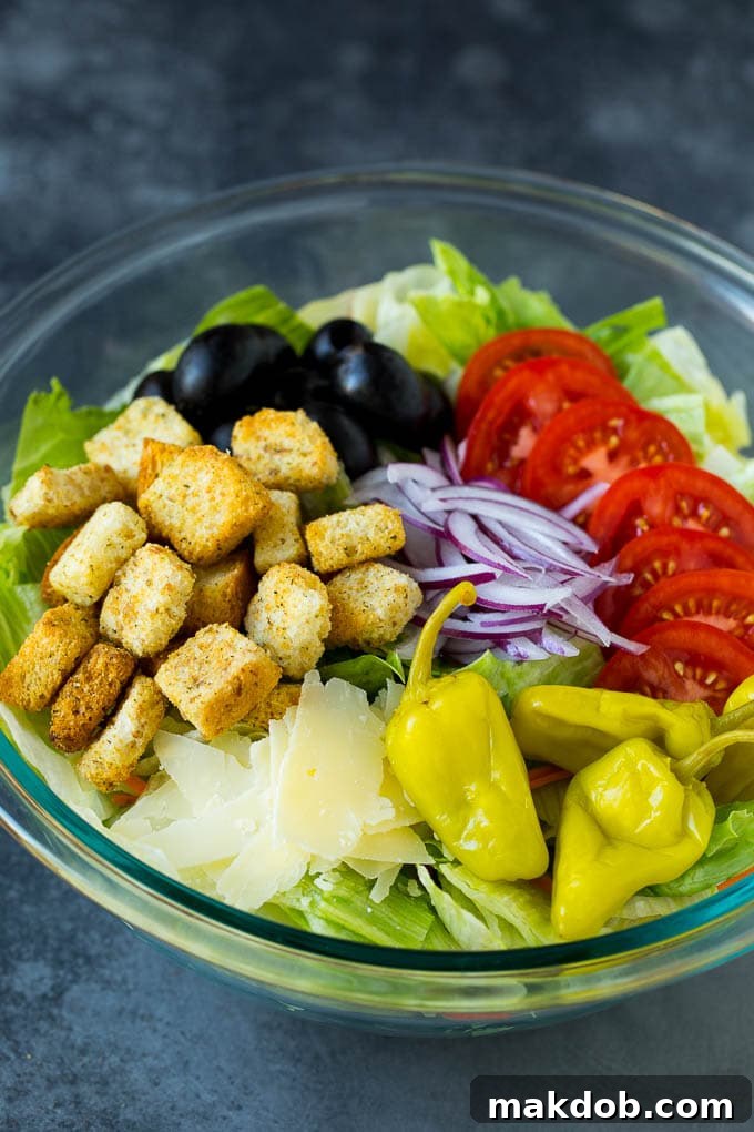 Lettuce, vegetables, olives and croutons in a bowl.