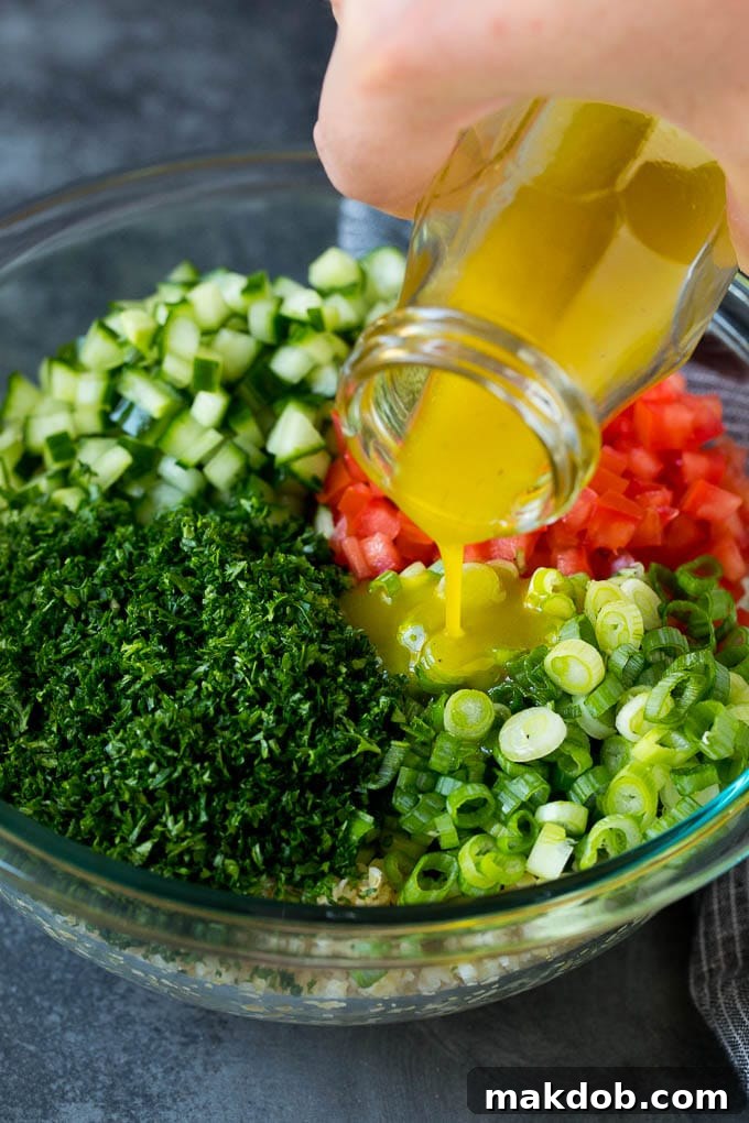 A vibrant lemon-herb dressing being drizzled over a fresh bulgur wheat salad with chopped herbs and vegetables, enhancing its flavor and appearance.