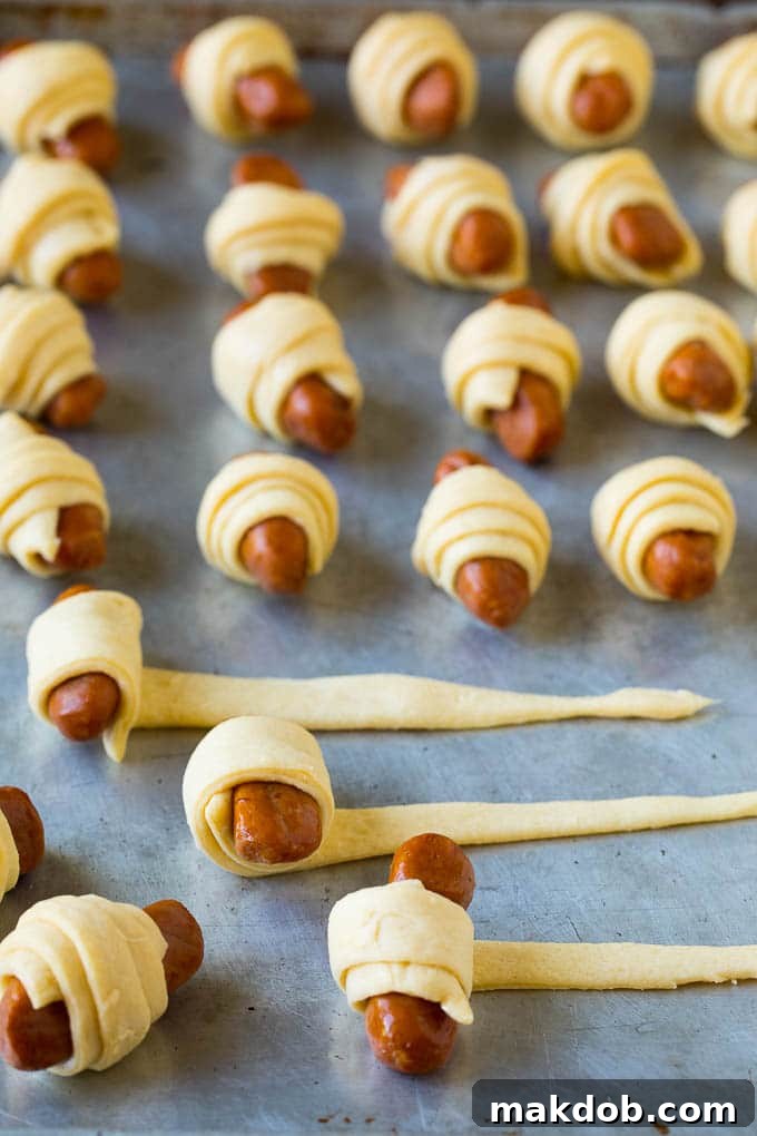 Hot dogs being rolled up in dough.