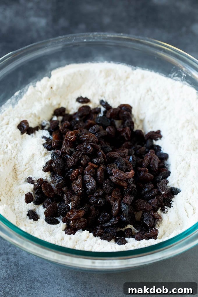 Irish Soda Bread Recipe #bread #baking #stpatricksday #sidedish #dinneratthezoo All-purpose flour, granulated sugar, baking soda, salt, raisins, and cold butter pieces in a mixing bowl, ready for preparation.