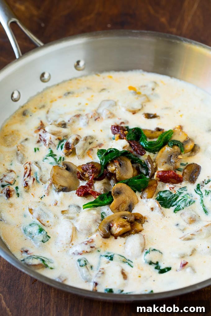 Rich, creamy Parmesan sauce with sautéed mushrooms, wilted spinach, and vibrant sun-dried tomatoes.