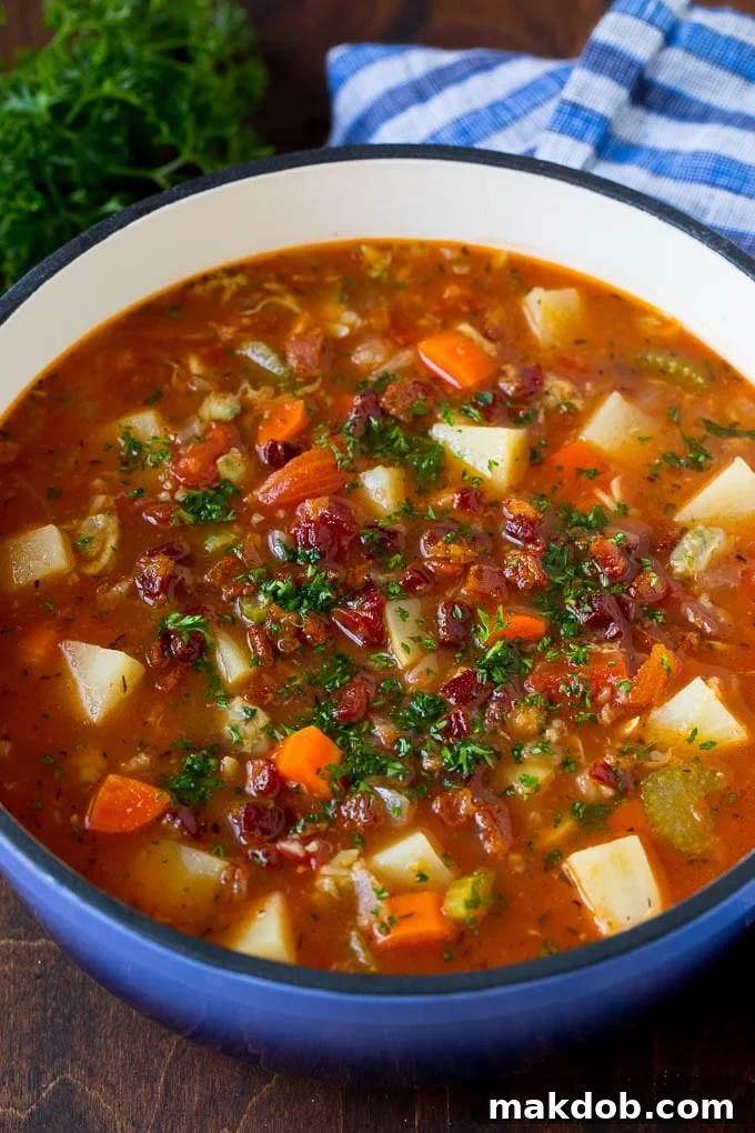 Manhattan clam chowder with tomatoes, potatoes, vegetables and bacon, garnished with parsley.