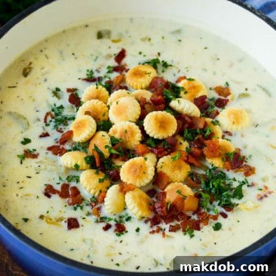 Coastal Comfort Clam Chowder 2 A pot of New England clam chowder topped with oyster crackers, bacon and parsley.