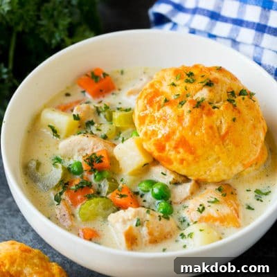 Homestyle Chicken Pot Pie Soup 2 A bowl of chicken pot pie soup with a biscuit on top.