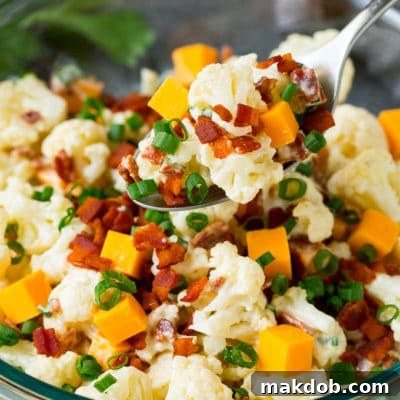 A spoon serving up a portion of cauliflower salad.