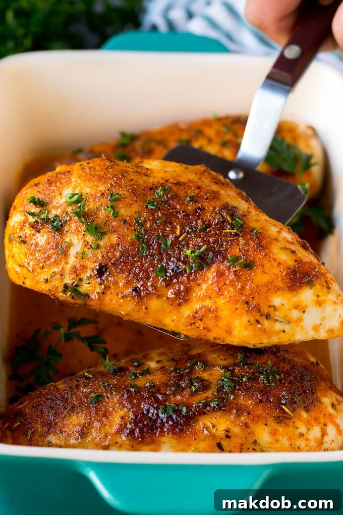 A spatula serving up a portion of roasted chicken breast.