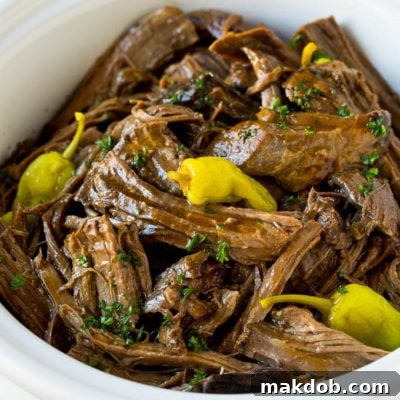 Zesty Mississippi Pot Roast 2 A slow cooker filled with shredded Mississippi pot roast.