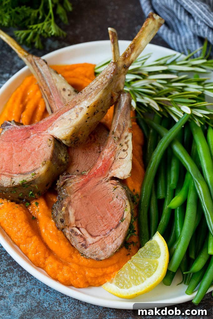 This rack of lamb is coated with garlic and fresh herbs, then roasted in the oven until tender and juicy. Rack of lamb served with sweet potatoes and green beans.
