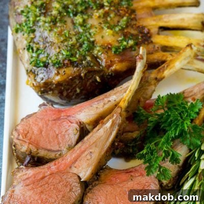 A platter of rack of lamb garnished with fresh herbs.
