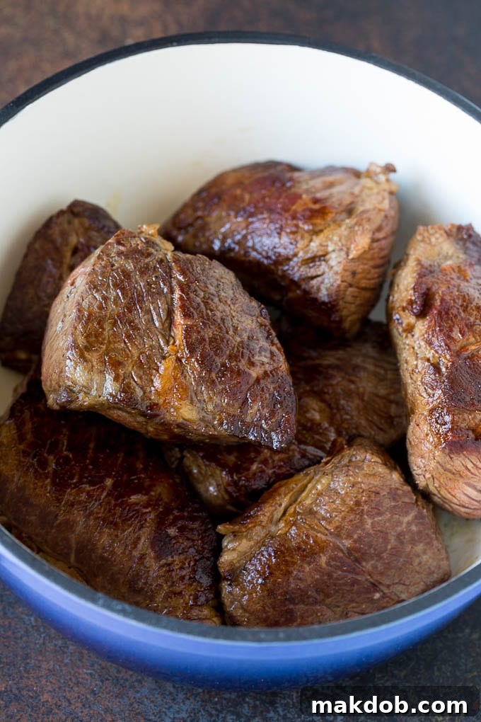How to Braise Short Ribs - Step by Step Guide Seared boneless beef short ribs in a pot, ready for braising.